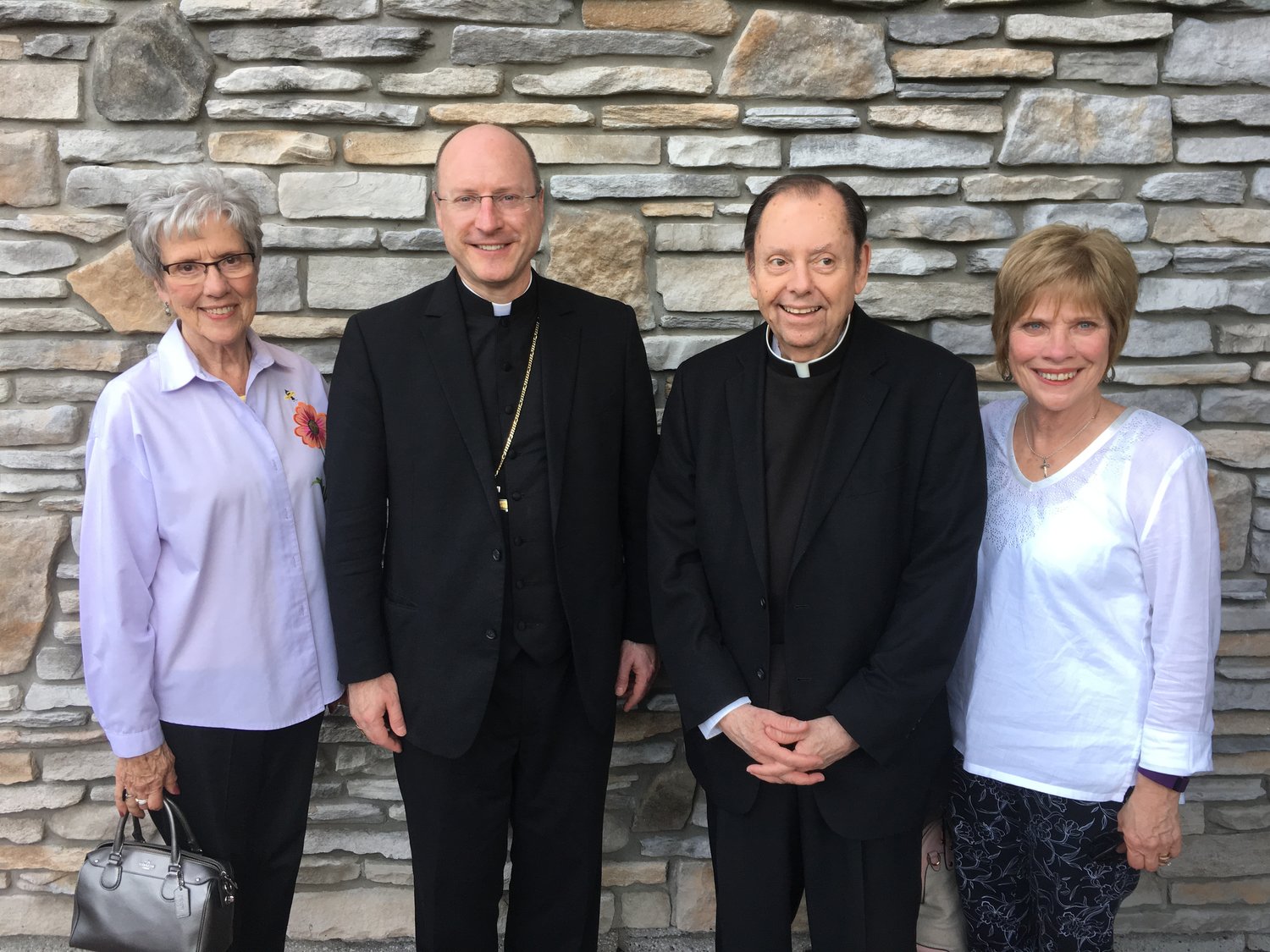 Bishop W. Shawn McKnight visits Monsignor Michael J. Wilbers, along with Msgr. Wilbers’s sisters, Mary Helen Norfleet and Julie Wieberg.